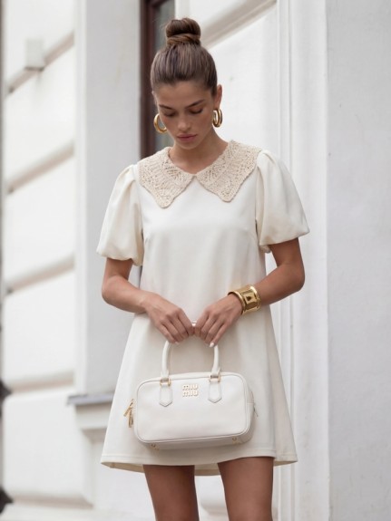 Śmietankowa sukienka koktajlowa z ozdobnym kołnierzykiem Cocomore